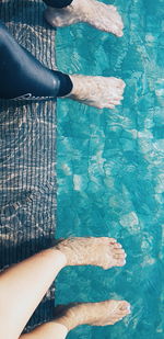 Low section of woman standing by swimming pool