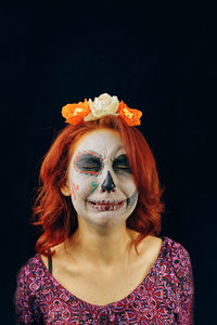 Portrait of woman wearing mask against black background