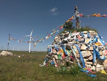 Low angle view of flags hanging on field against sky