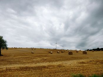 Hay bales on field against sky