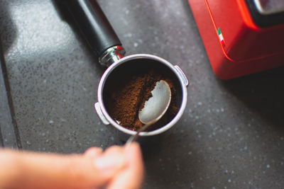 Cropped hand making coffee at table