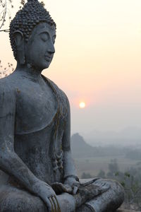 Statue of buddha at sunset