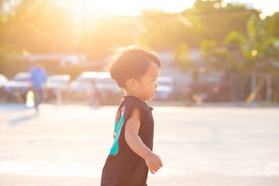 Boy looking away while standing on land