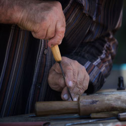 Midsection of man working on wood