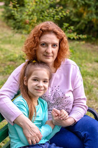 Portrait of a happy woman and daughter smiling and looking at the camera.