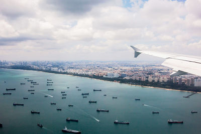 Aerial view of sea and cityscape against sky