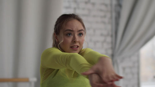 Ballet dancer stretching against wall