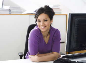 Portrait of young woman sitting in office