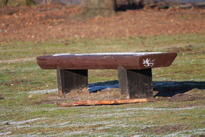 Empty bench on field at park