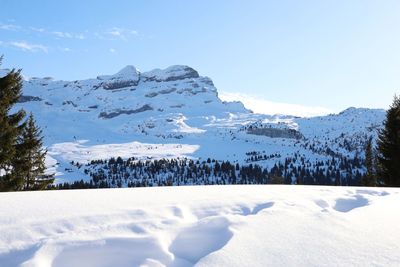 Scenic view of snow covered mountains against sky