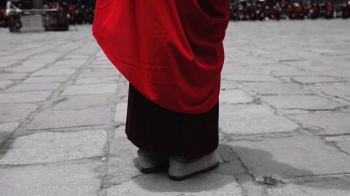 Low section of buddhist monk standing on footpath