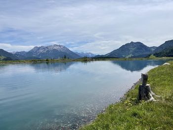 Scenic view of lake by mountains against sky