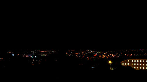 Illuminated cityscape against sky at night