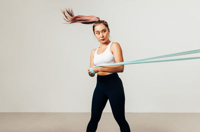 Full length of woman standing against wall