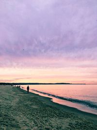 Silhouette man standing on beach against sky during sunset