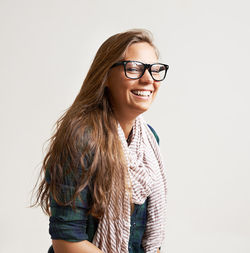 Portrait of young woman standing against white background