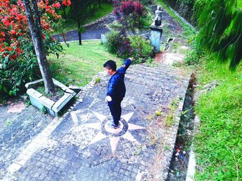 Full length of boy on footpath by plants