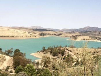 Scenic view of lake and mountains against clear sky