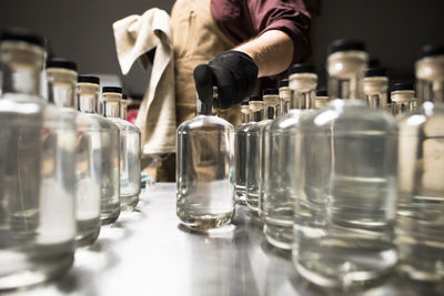 A distiller filling bottles of liquor.