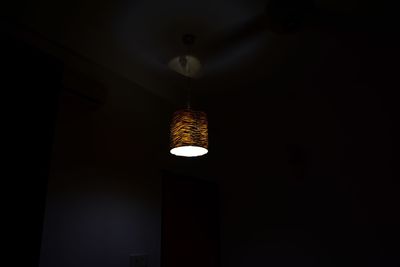 Low angle view of illuminated lighting equipment hanging from ceiling