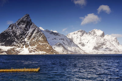 Scenic view of snowcapped mountains against blue sky