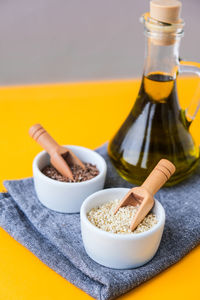 Sesame and flax seeds wooden spoons with oil in glass bottle. healthy food concept. vegan keto diet