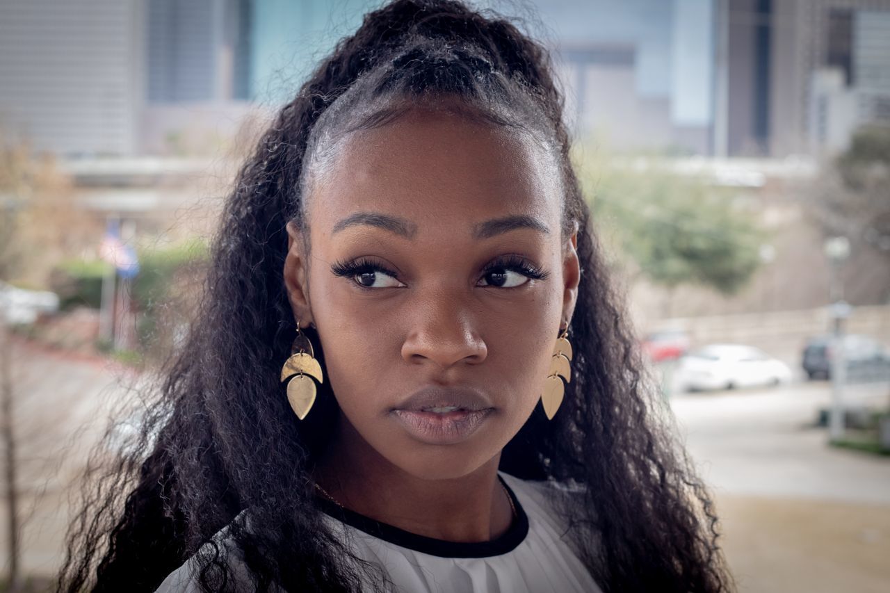 portrait, headshot, looking at camera, one person, young adult, young women, front view, hair, focus on foreground, hairstyle, city, lifestyles, real people, leisure activity, architecture, beauty, women, long hair, beautiful woman, outdoors, teenager