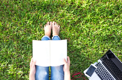 Low section of person with book on field