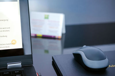 Close-up of laptop and mouse on table