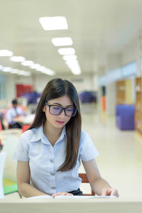 Portrait of a young woman sitting on table