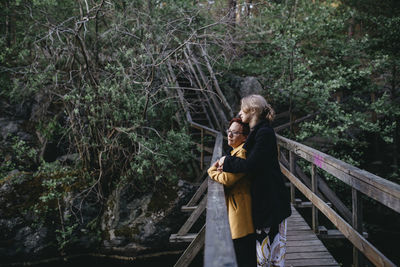 Female couple standing on footbridge