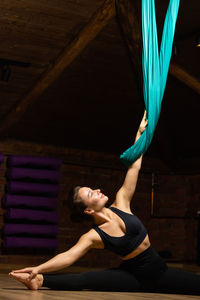 Full length of young woman exercising at home