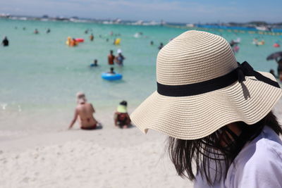 Portrait of woman with hat on beach