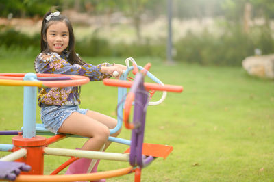 Full length of woman sitting on slide at playground