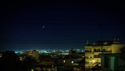 Illuminated cityscape against clear sky at night