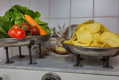 Close-up of potato chips and various vegetables on weight scale