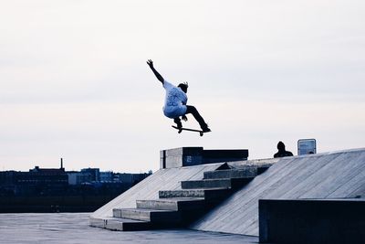 Low angle view of woman jumping in mid-air