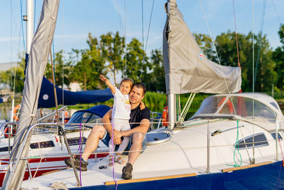 Portrait of father with daughter sitting on boat