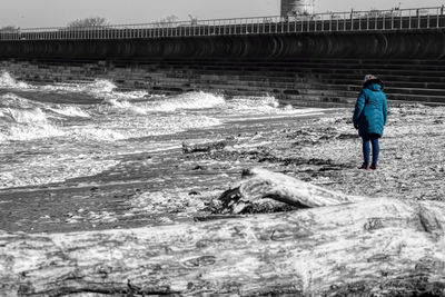 Rear view of men walking in sea