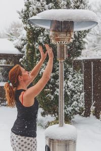 Young woman with arms raised in snow