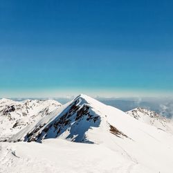 Scenic view of snowcapped mountain against blue sky