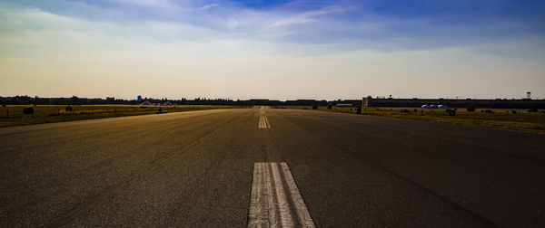 Empty road on field against sky