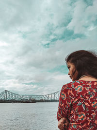 Woman looking at sea against sky