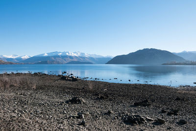 Scenic view of beach against clear blue sky