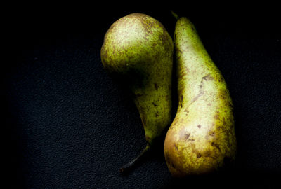 Close-up of fruits on table against black background