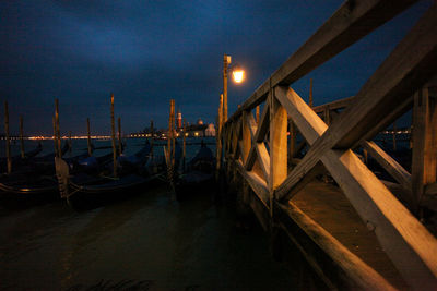 Pier over sea against sky at night