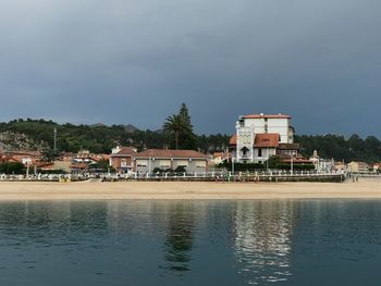 Houses by sea against sky