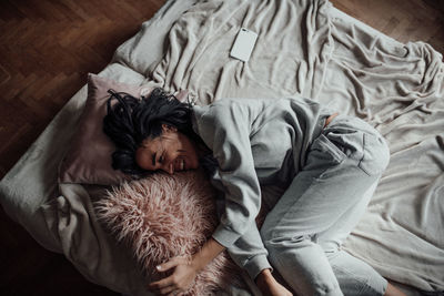 High angle view of woman lying down on bed at home