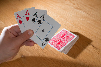 Close-up of hand holding playing cards on table