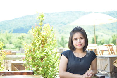 Portrait of a smiling young woman sitting on table